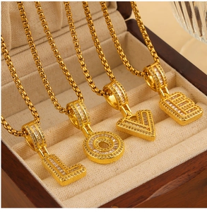 Dettaglio della collana a catena a scatola dorata con pendenti LOVE e pietre di zircone