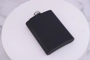 Detail of matte black stainless steel flask with silver screw cap on marble base