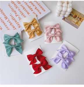 Detailed flat lay of colorful fabric bow hair clips set on elegant display cards
