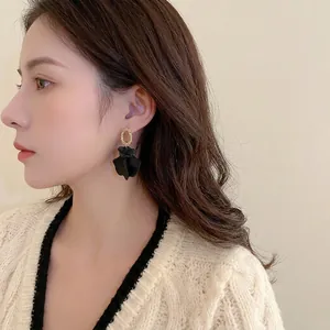French vintage earrings with golden textured studs and matte black petal pendants