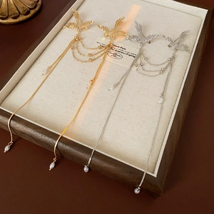 Detailed close-up of bird-shaped tassels with elegant long chains and white pearls