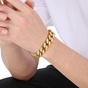 Detail of vintage gold Cuban chain bracelet with embossed edges on a male wrist
