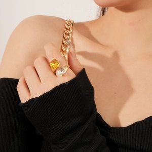 Detail of elegant gold double-stone open ring with yellow and white crystals on finger
