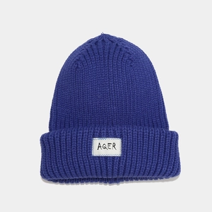 Detailed knit texture of royal blue beanie with a square AQER fabric patch