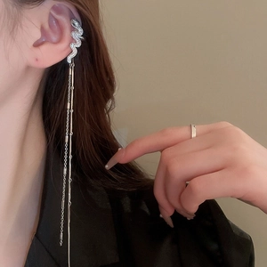 Manchette d'oreille serpent argentée avec longs pompons et zircons portés sur l'oreille