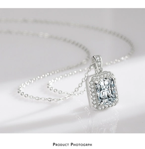 Close-up of silver necklace featuring a rectangular cut zirconia pendant with halo setting