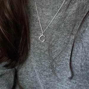 925 sterling silver necklace featuring a minimalist oval letter C pendant on a model