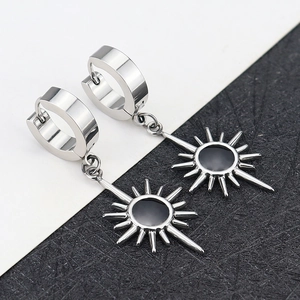Detail of silver titanium steel earrings with starburst pendants and black centers