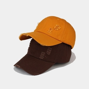Detailed view of washed vintage baseball caps in mustard yellow and dark coffee brown fabric