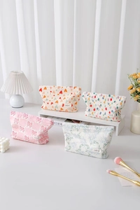 Quattro pochette per trucchi in tela con motivi a cuori, pois, fiori e fiocchi