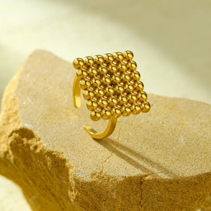 Macro detail of 18K gold plated square beaded panel on adjustable stainless steel ring