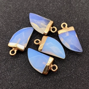 Close-up of five blue moonstone chili-shaped pendants with gold plating for jewelry DIY