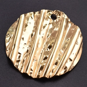 Macro detail of a 304 stainless steel golden round pendant with unique hammered textures