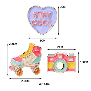 Vue détaillée du set de pins émaillés avec cœur, patins à roulettes et motifs d'appareil photo