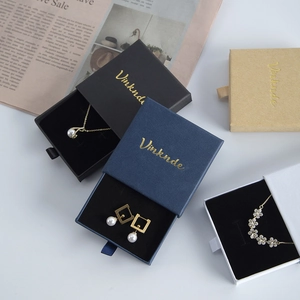 Detailed drawer jewelry boxes in black, blue, and white with elegant gold logo printing