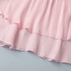 Detail of soft pink chiffon ruffles with a pearlescent finish and micro-pleat texture