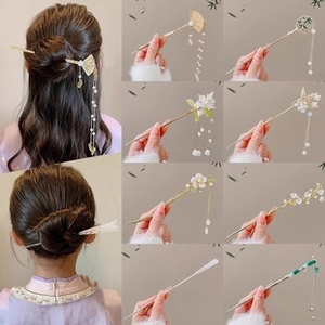 Detail showing elegant metal hair sticks with pearls and flowers in golden and silver finishes