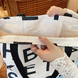 Detail of canvas tote bag interior showing the inner pocket and durable stitching