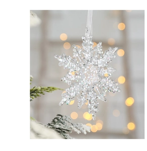 Detailed close-up of clear acrylic snowflake ornament with silver glitter for Christmas tree