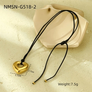 Detailed view of 2.7cm gold heart pendant on black cord with weight specifications
