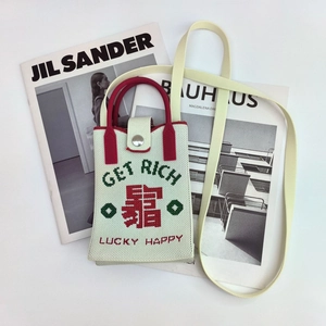 Detail of knitted phone bag with Get Rich typography on minimalist magazines