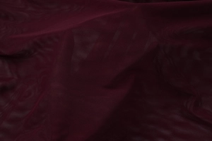 Gros plan sur le tissu en maille fine bordeaux avec texture respirante et drapé doux