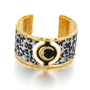 Wide gold cuff bangle with leopard print pattern and central moon face ornament