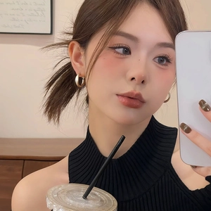 Close-up of minimalist golden hoop earrings worn by a model for a stylish lifestyle look