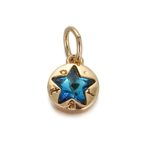 Detail of a round gold pendant with a blue star crystal and intricate edge engraving