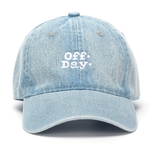 Detail of light blue denim baseball cap with Off Day embroidery and washed fabric texture
