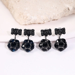 Primer plano de pendientes de lazo de cristal negro con colgantes de esfera