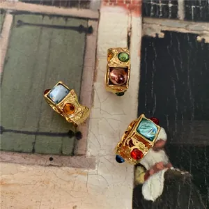 Detailed shot of vintage gold rings with hammered texture and colorful gemstones
