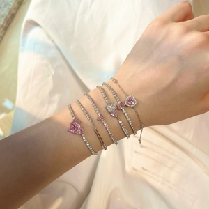 Detailed view of layered S925 silver tennis bracelets with pink heart zircon and stones