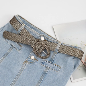 Fashionable sparkling rhinestone belt with oval buckle on denim jeans background
