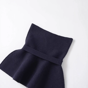 Women's chic navy knit top with peplum hem and bow tie detail in minimalist style