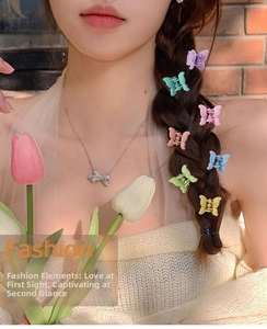 Close-up of pastel candy-colored butterfly mini hair claws worn on a young girl hair