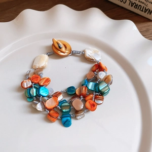 Detailed view of multilayer shell bead bracelet with colorful stones and wood button closure