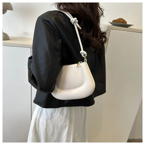 Close-up of white minimalist saddle bag with cloud-shape design and knot shoulder strap