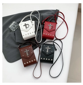 Detail of vintage gothic crossbody bag with metallic cross and star studs in various colors