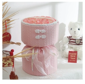 Close-up of pink knitted flower bucket with roses, Chinese buttons and LOVE ribbon