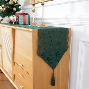 Green crochet lace table runner with tassels featuring vintage festive patterns