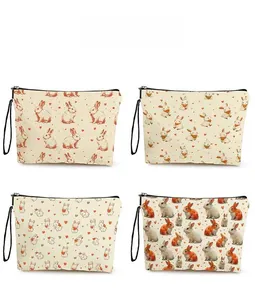 Detail showing four bunny patterns on white zipper makeup bags with wrist straps