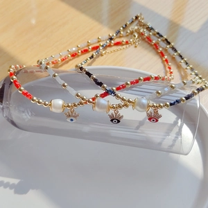 Détail du pendentif œil protecteur avec perles colorées et perles d'eau douce