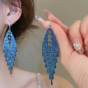 Deep blue rhinestone triangle tassel earrings shown on ear with elegant hanging design