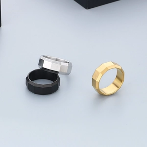 Detail of 8mm brushed faceted stainless steel rings in black, silver, and gold finishes