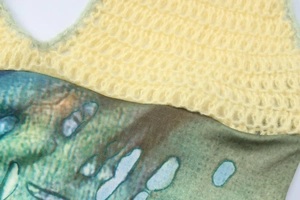 Detail of yellow knit hollow texture joined with blue and green animal print fabric