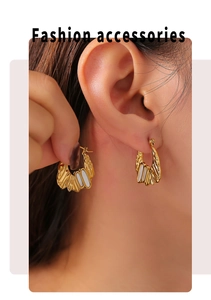Detail showing irregular 18k gold shell earrings worn on ear for chic fashion style