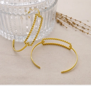 Detail of 18K gold plated minimalist open bracelets featuring beaded rectangle design