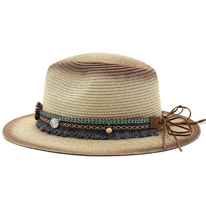 Detail of bohemian woven straw hat with tribal beads, tassels, and coin pendant