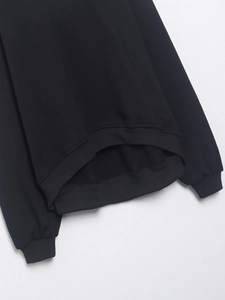 Detalle de los puños y el dobladillo acanalados de la sudadera negra con textura de punto fino